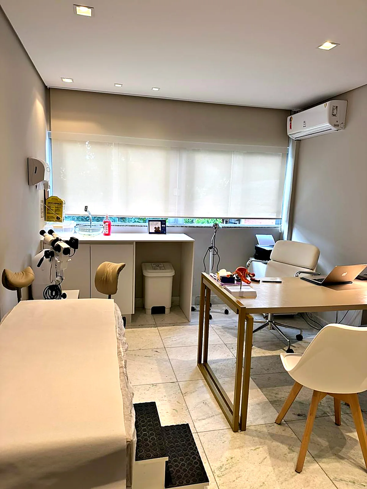 Consultório com maca, mesa e armários